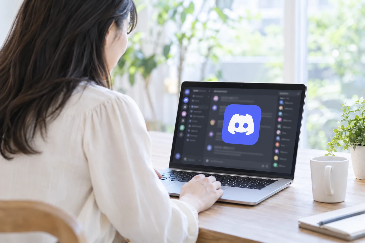 パソコンの画面にDiscordを開き、コミュニティに参加する人のイメージ